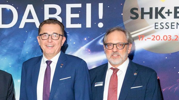 Nicht mehr im Auftrag des Fachverbands SHK NRW bei der SHK+E Essen 2026 dabei sein wird Frank Hehl (rechts), auch wenn er sich mit ZVSHK-Präsident Michael Hilpert (links) beim Herbstempfang im Oktober noch vor dem Poster zeigte. Bild: FV SHK NRW